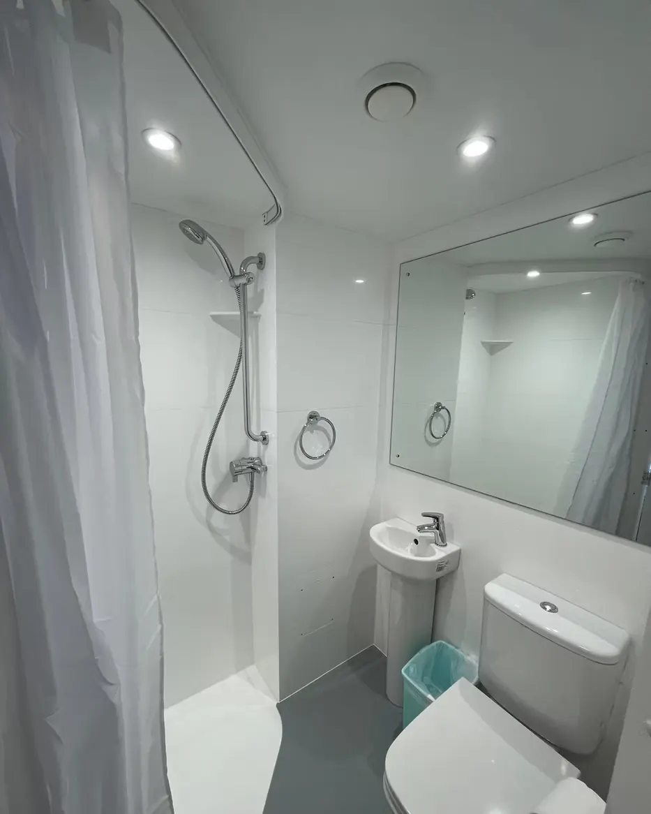 Clean private bathroom with shower, sink, and toilet