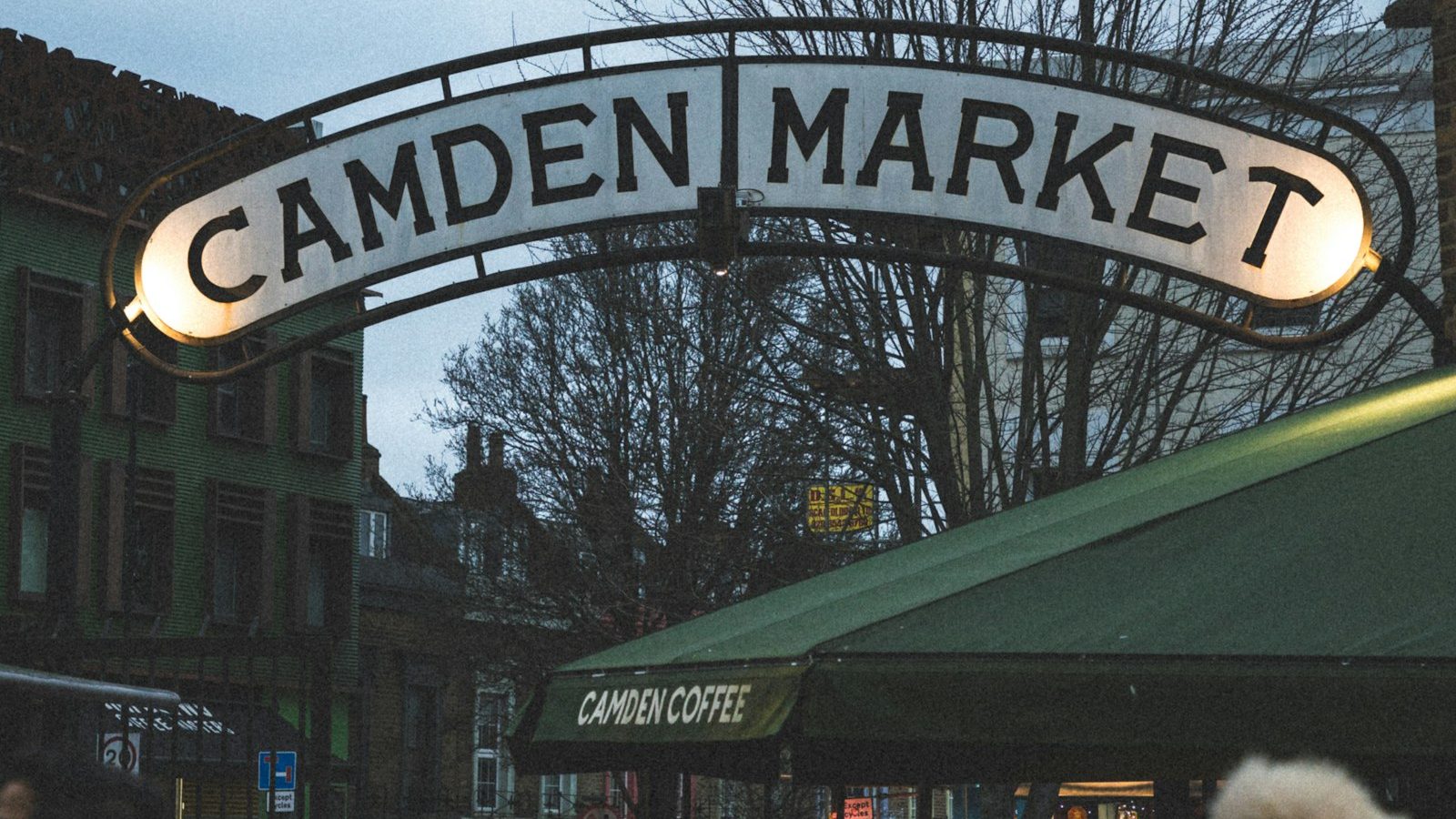 Folla che passa sotto l'insegna illuminata di Camden Market, nel nord di Londra