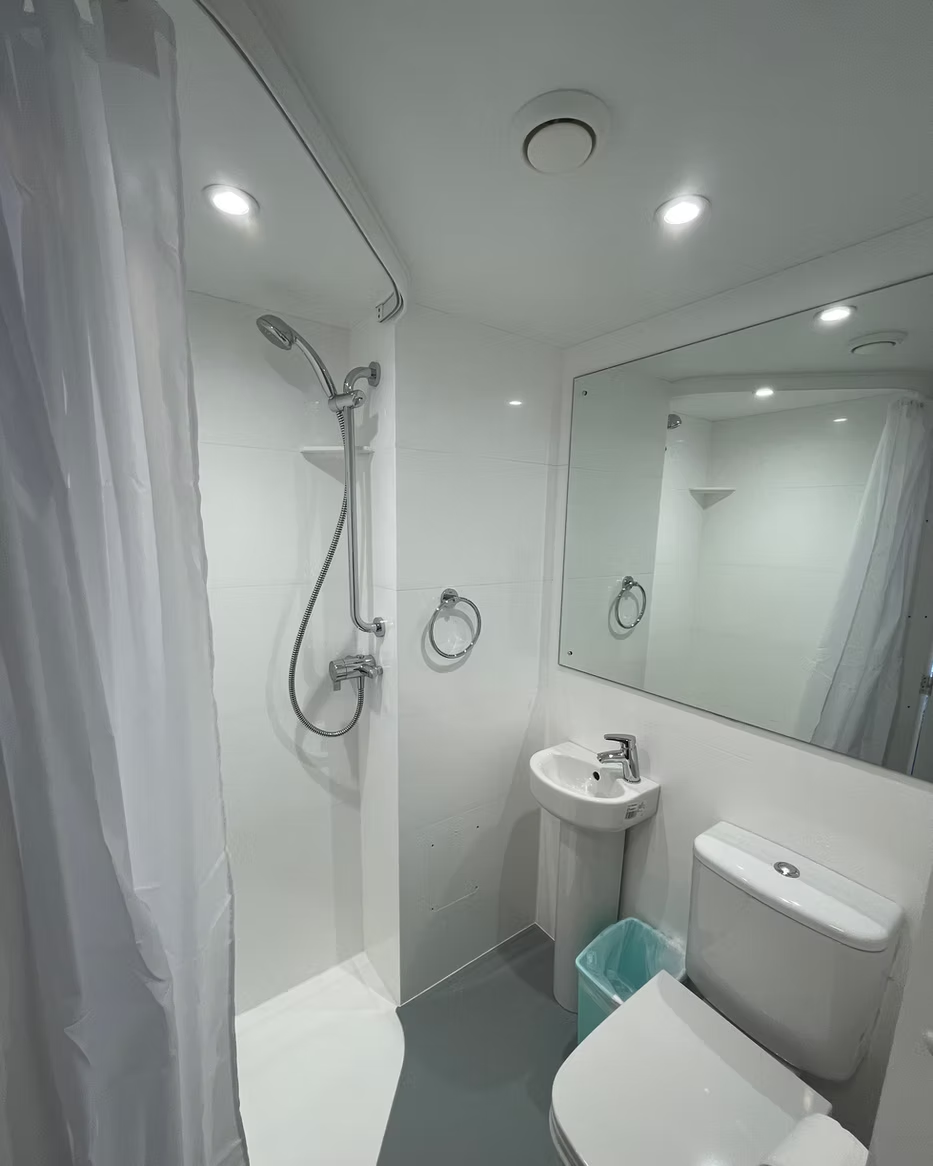 Clean private bathroom with shower, sink, and toilet